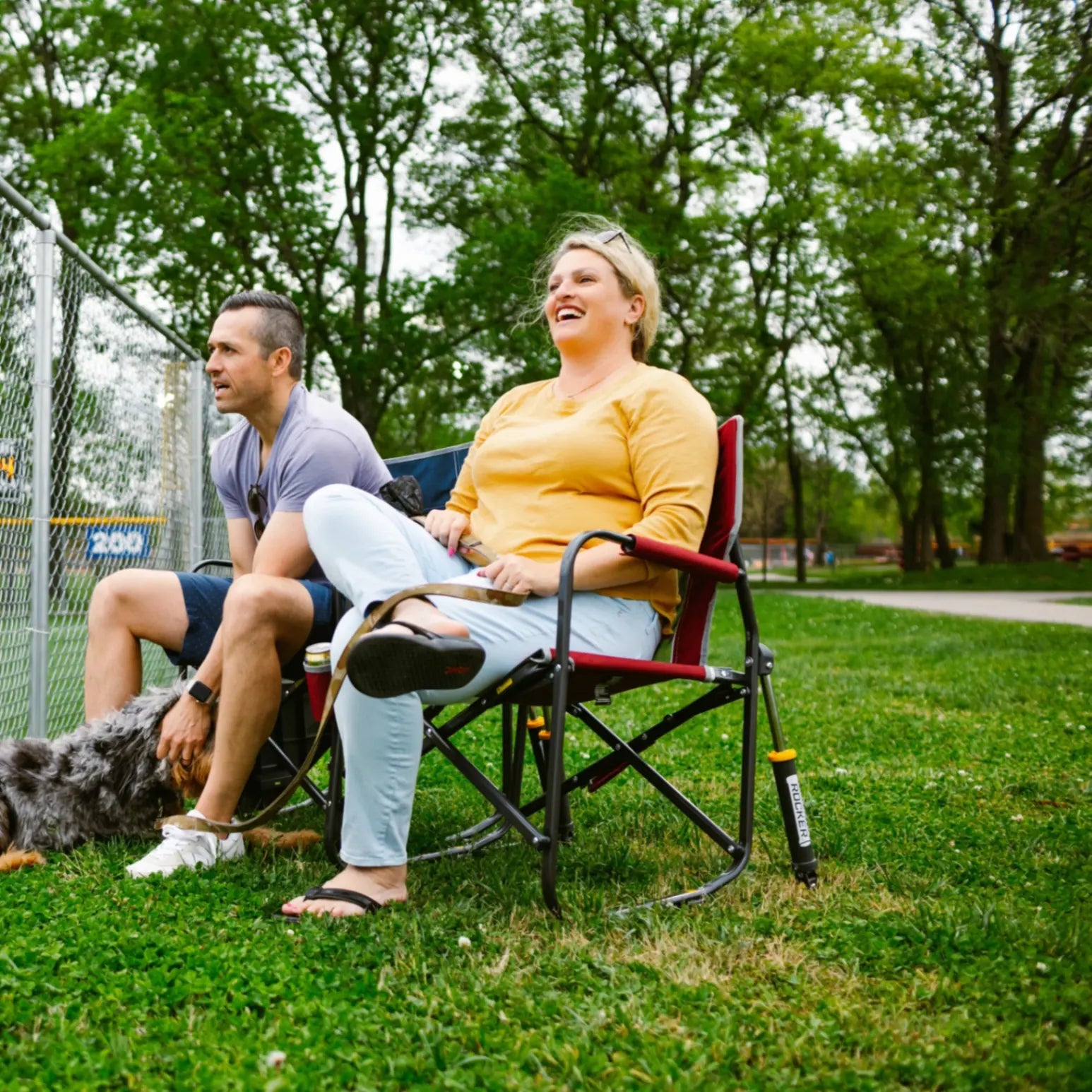 A couple watching a baseball game while sitting in their Freestyle Rocker chairs.