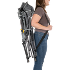 Person using the shoulder strap to carry the gray kickback rocker chair.