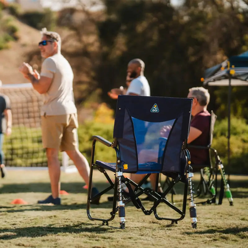 Adjustable Rocker chair faces a volleyball game, with people clapping and watching in the background.