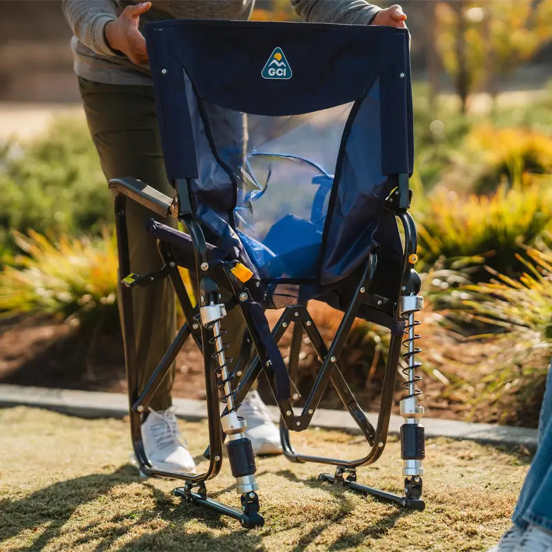 Adjustable Rocker in navy being unfolded, showing its breathable mesh back panel and spring-loaded legs.