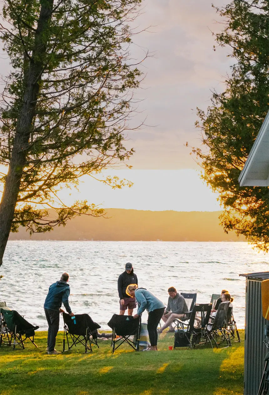 A group of people by a body of water sitting in pod rocker elite chairs.
