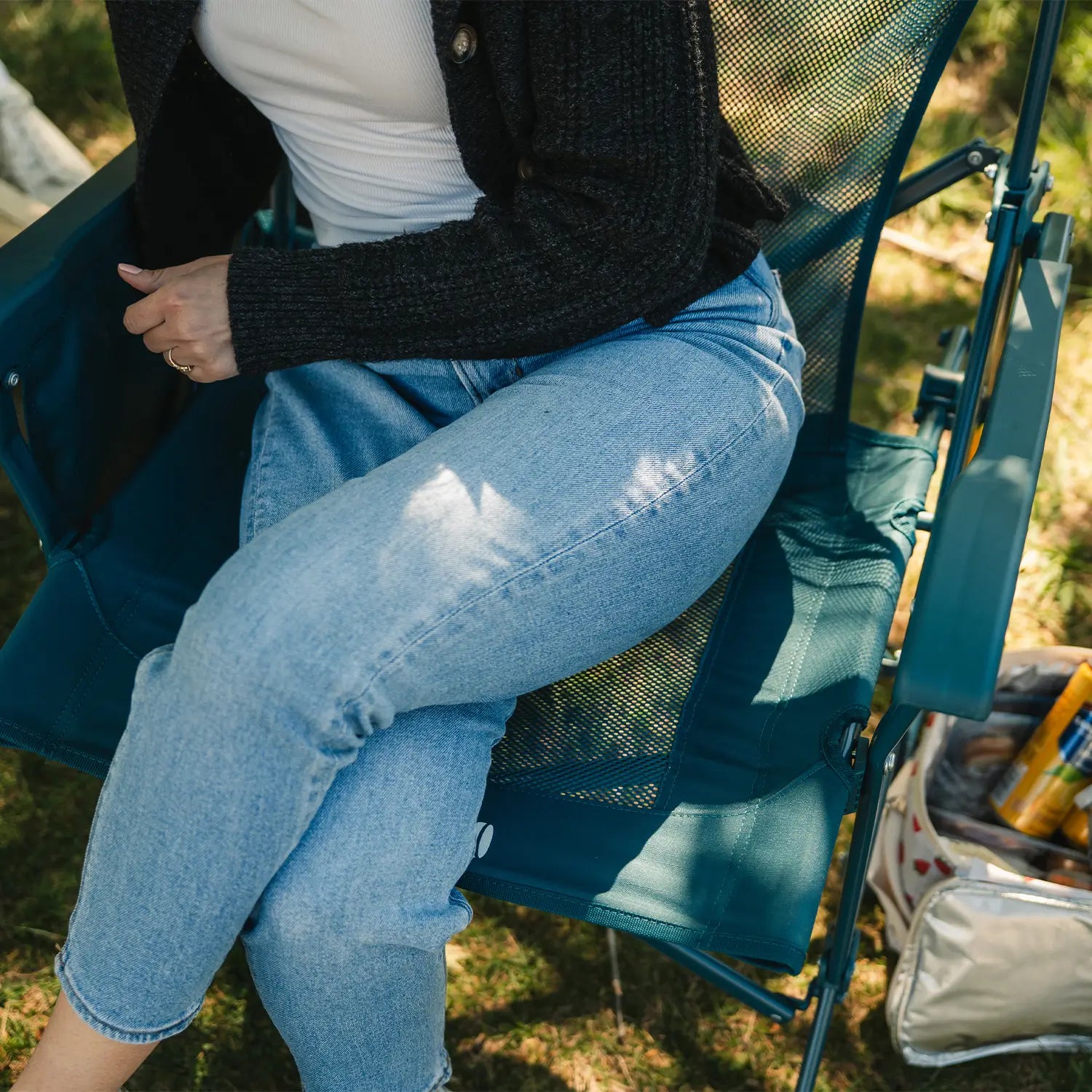 An aerial view of a woman sitting on a teal BreezeRocker showing the mesh backrest and seat.