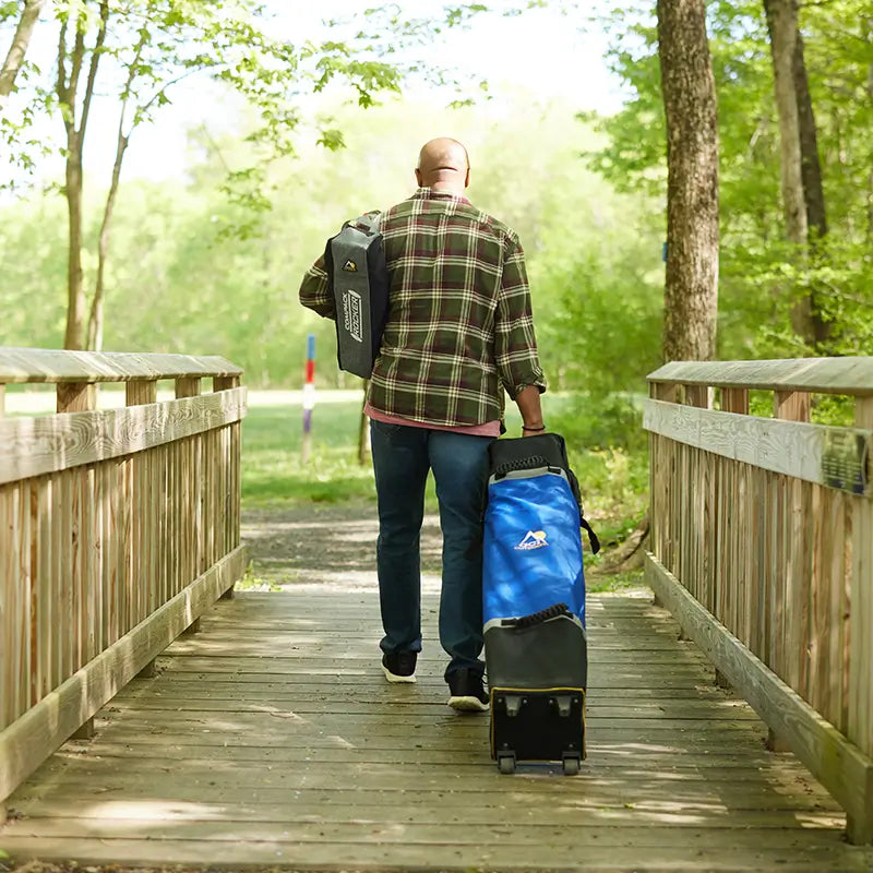 all-groups A man pulling along a packed Levrup Canopy and carrying a packed Compack Rocker.