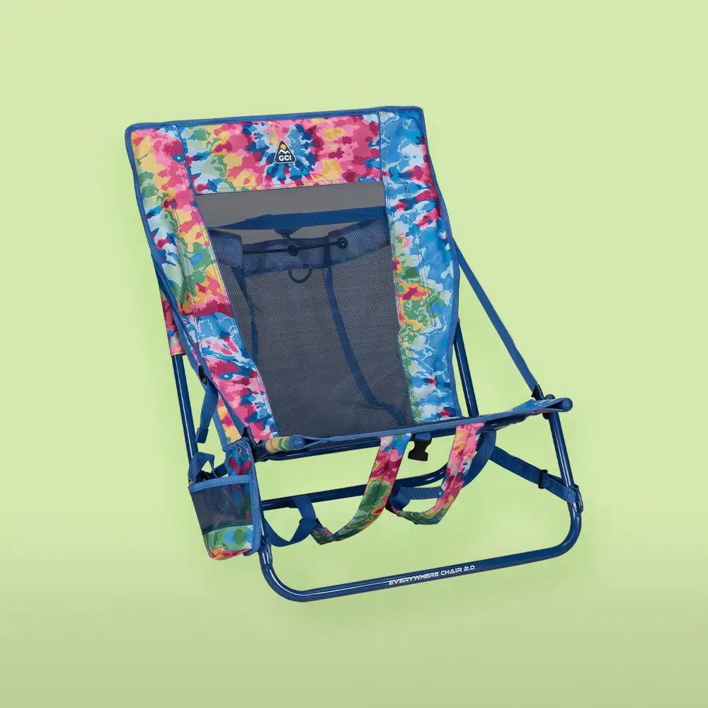 A tie dye everywhere chair 2 in front of a green background.
