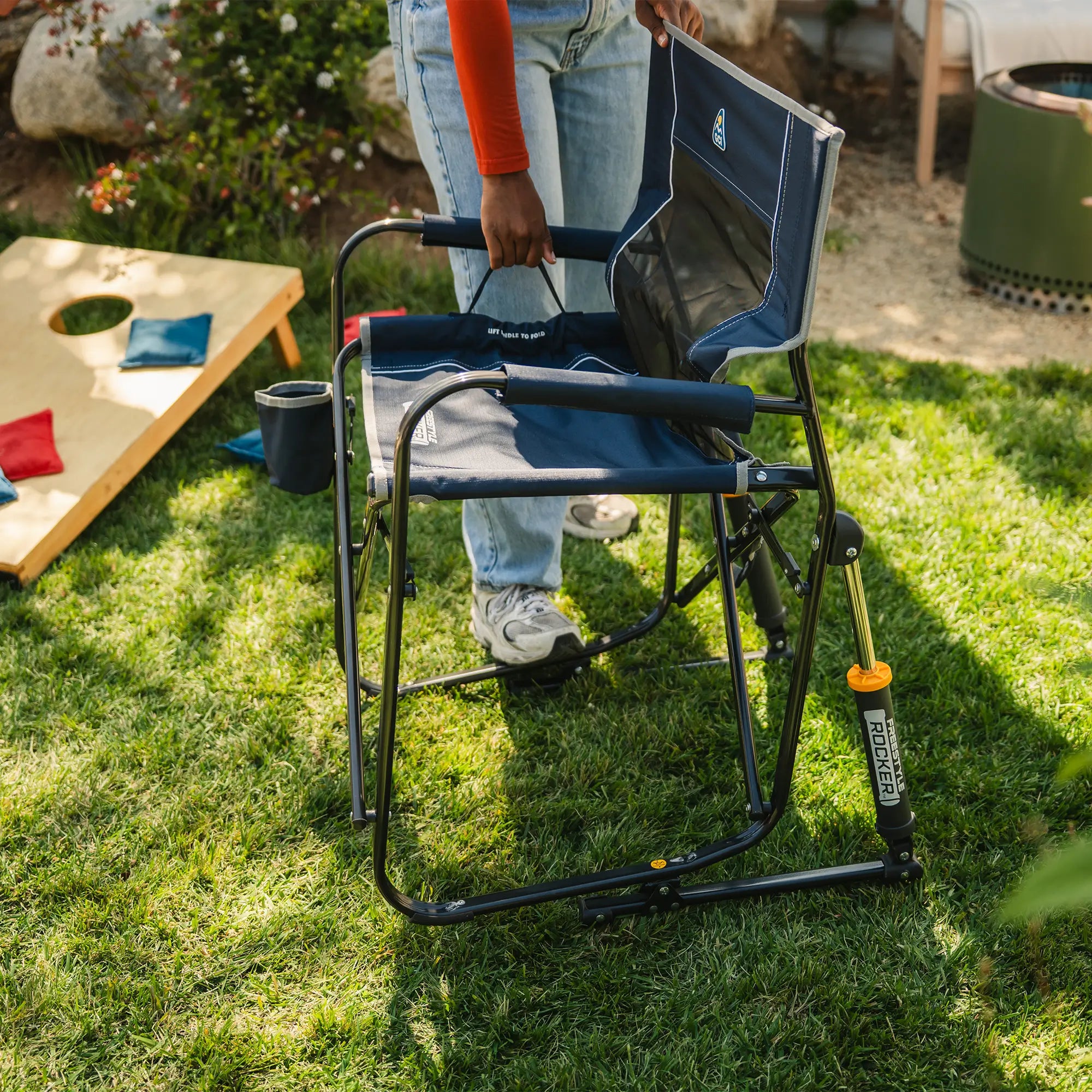 A woman closing an indigo freestyle rocker by pulling on the eazy folding technology on the seat.