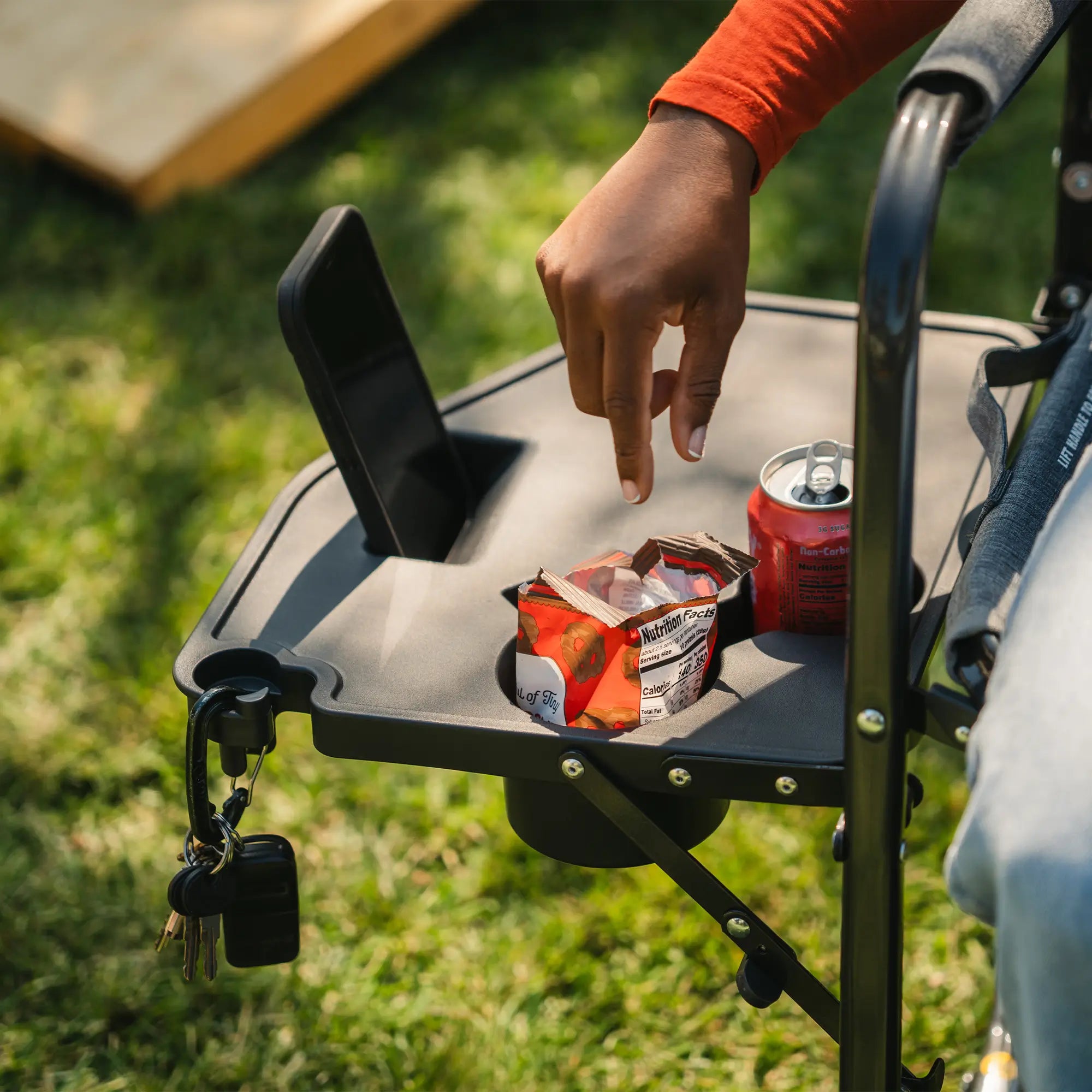 A woman reaching for a snack that is positioned in the side table of her freestyle rocker with side table.