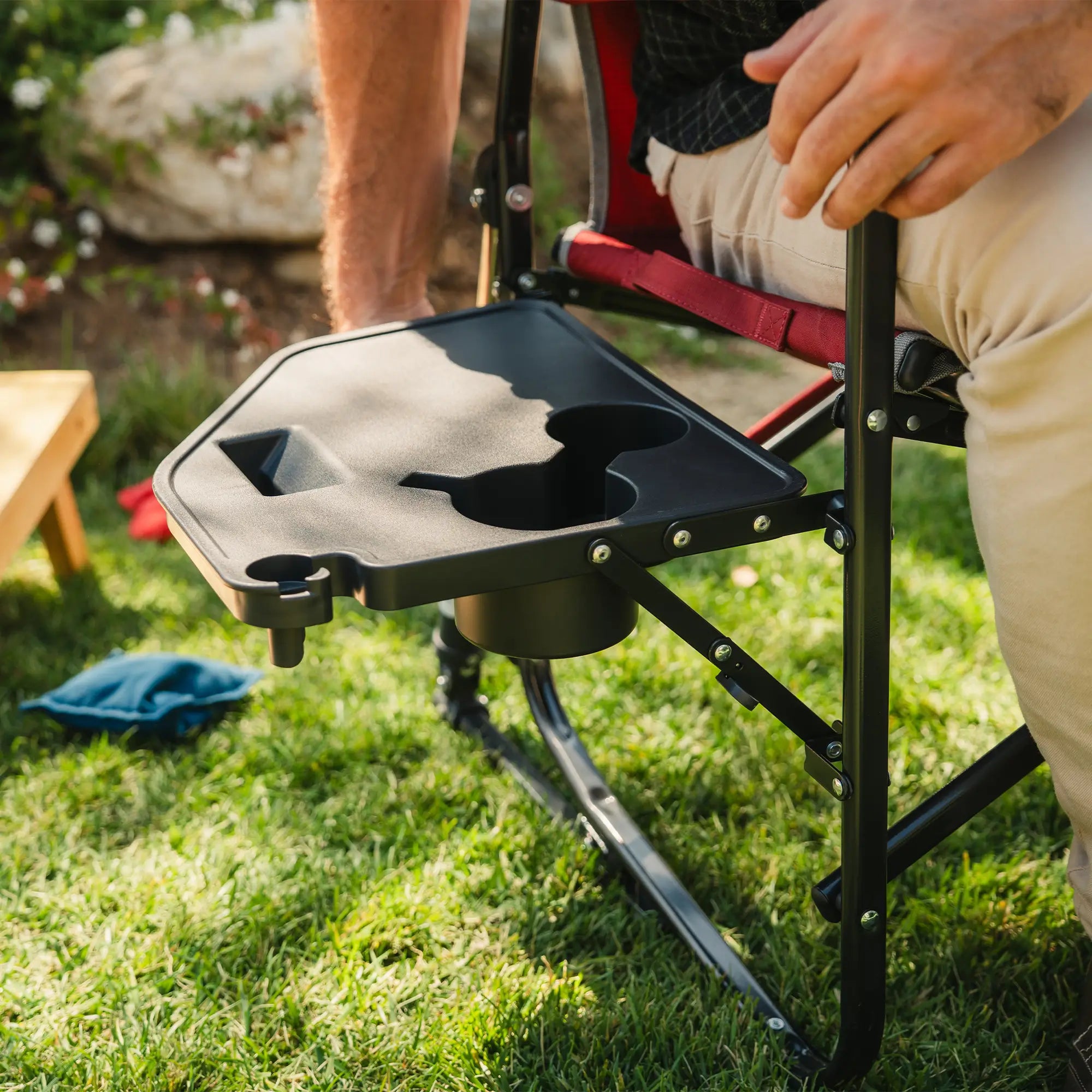 A man folding up his side table on his cinnamon freestyle rocker with side table.