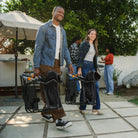 Two people carrying their black freestyle rocker xl with side table by using the integrated carry handle.