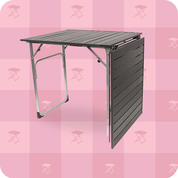 A slim-fold table in front of a pink patterned background.