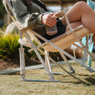 Side view of the Soft Neutral Leaf Kickback Rocker showing rocker springs and mesh storage.