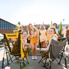 A group of ladies posing for a picture with their fingers up while sitting in their iowa state comfort pro rocker chairs.