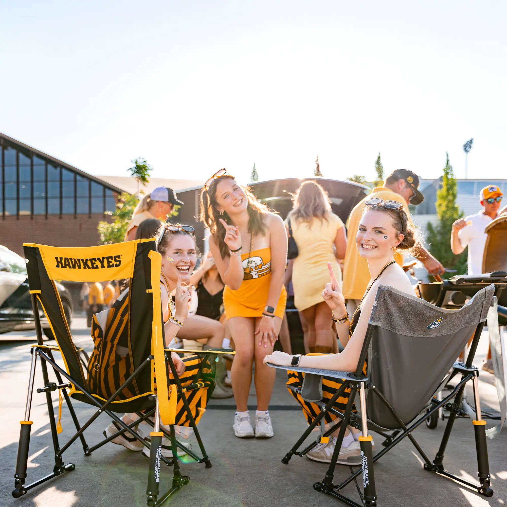 A group of ladies posing for a picture with their fingers up while sitting in their iowa state comfort pro rocker chairs.