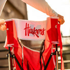 A person collapsing the nebraska cornhusker comfort pro rocker chair.