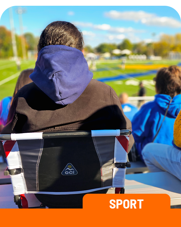 Person sitting in a GCI stadium seat at a sports event with a black jacket on. Labelled 'Sport'