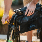 Close-up of hands unfolding the stealth camo Stowaway Rocker by pulling the yellow release strap.