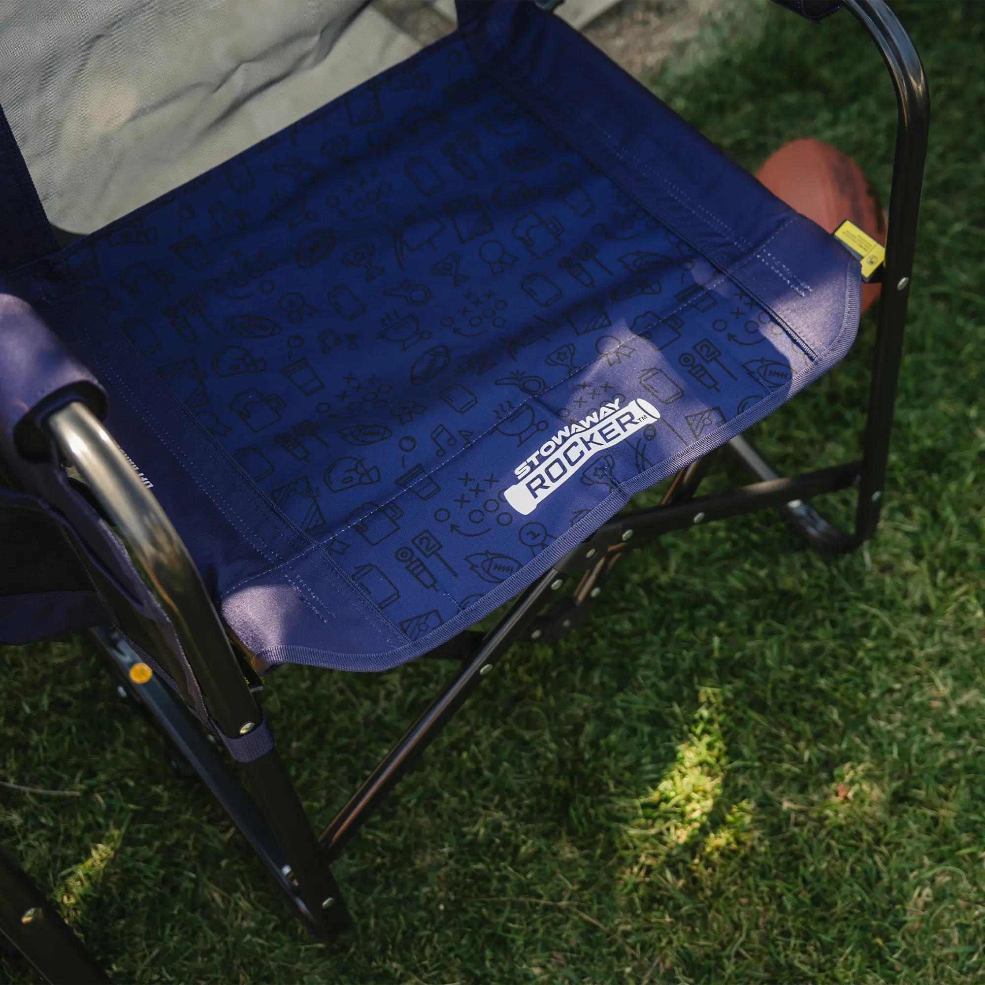 An up-close of the blue tailgater patterned print on the seat of the stowaway rocker.