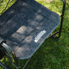 An up-close of the gray tailgater patterned print on the seat of the stowaway rocker.