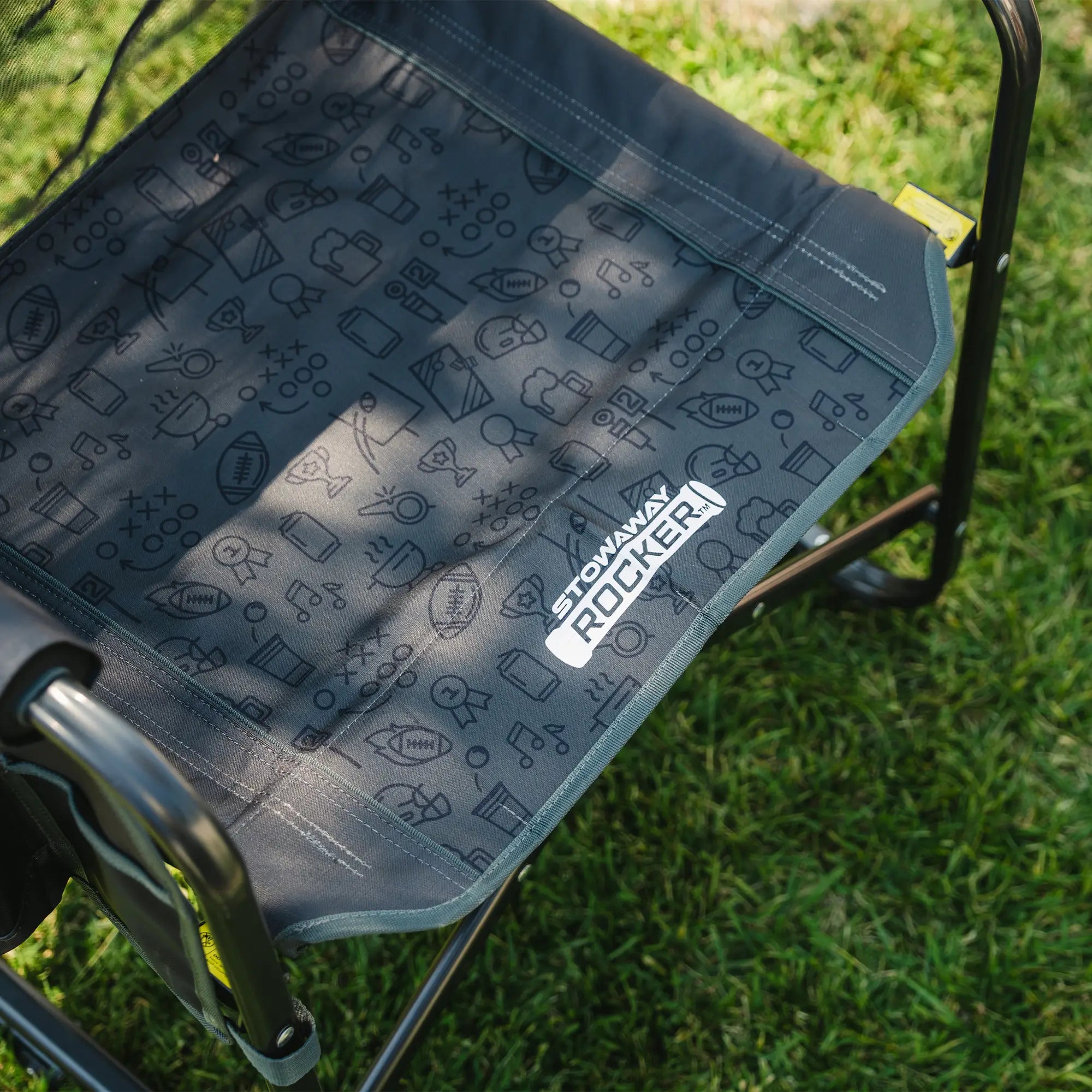 An up-close of the gray tailgater patterned print on the seat of the stowaway rocker.