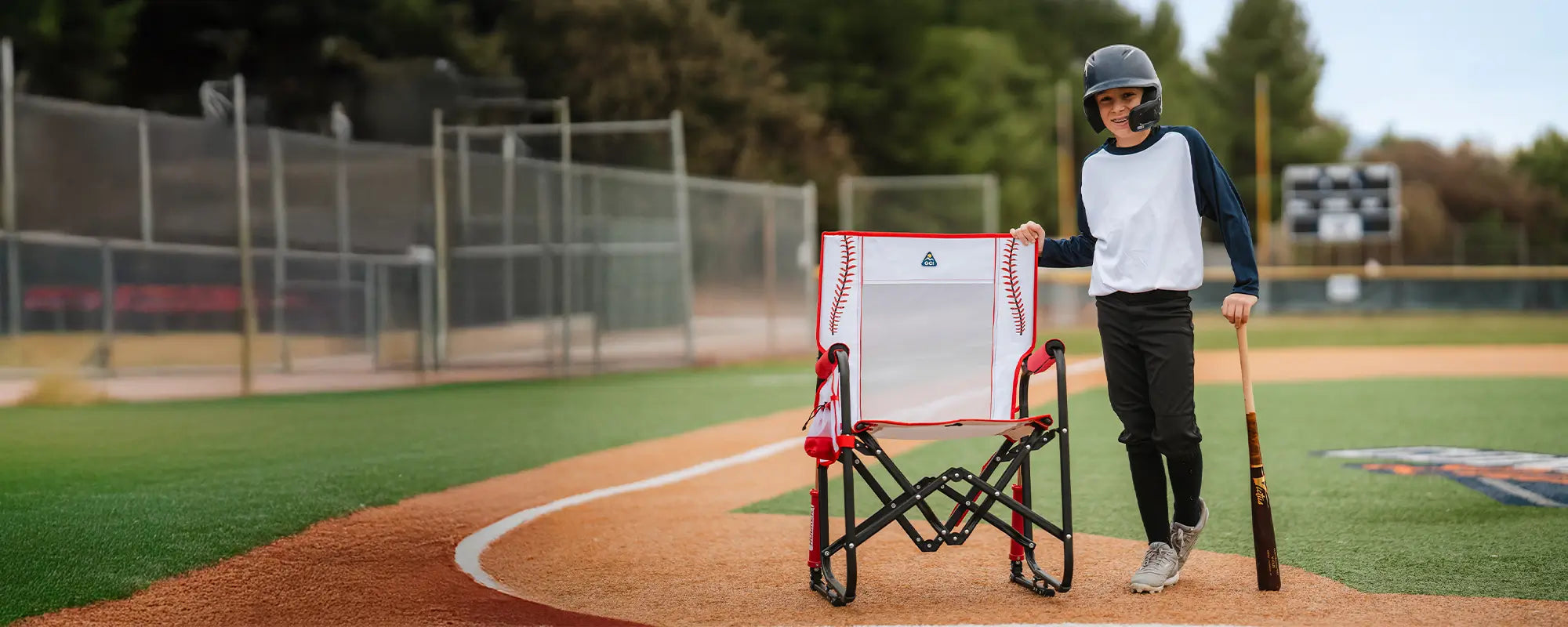 A baseball player standing next to a baseball print stowaway rocker.