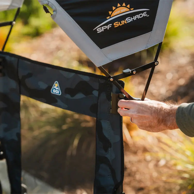 Close-up of black sunshade being attached to camo GCI chair for UPF 50+ protection.