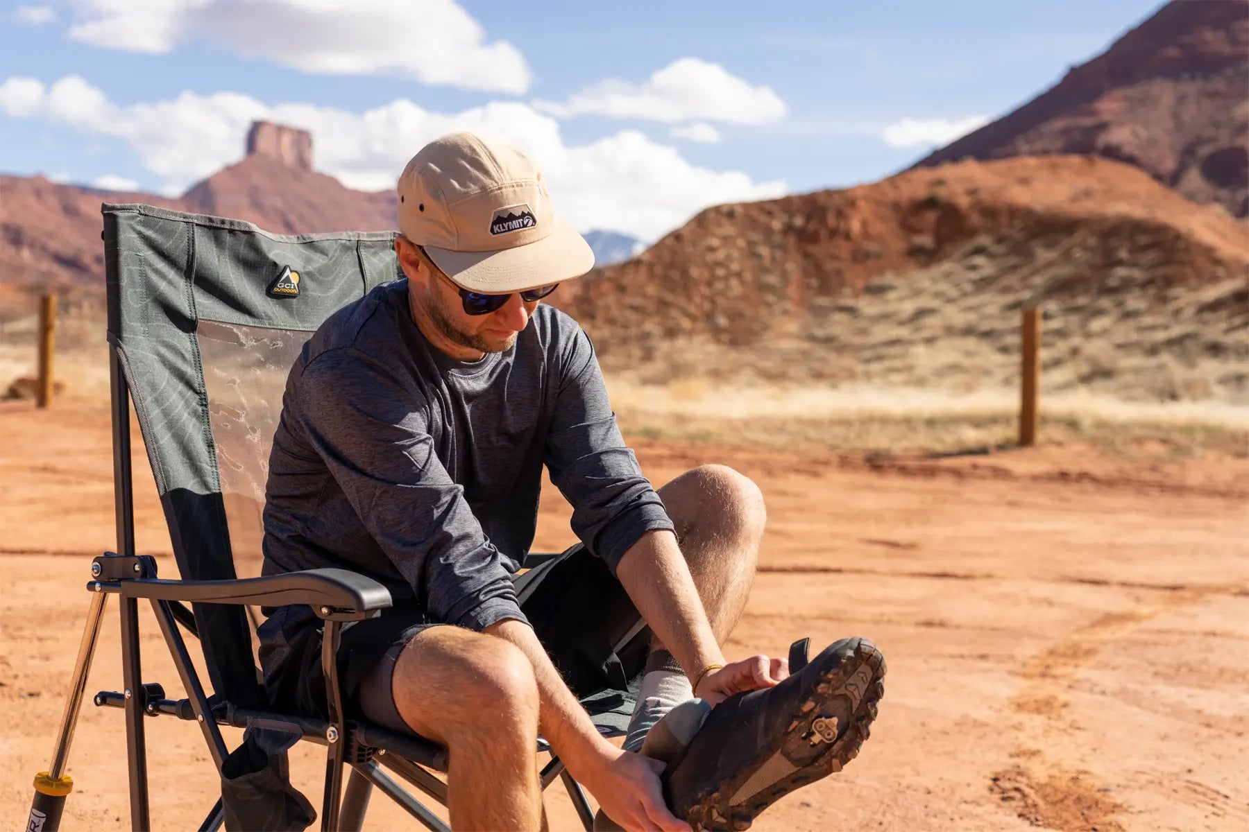 Man relaxes in comfort pro rocker near desert cliffs.