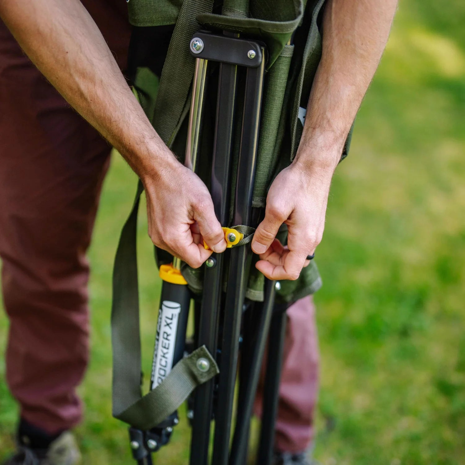 Close-up of hands folding a heathered olive Comfort Pro Rocker XL.