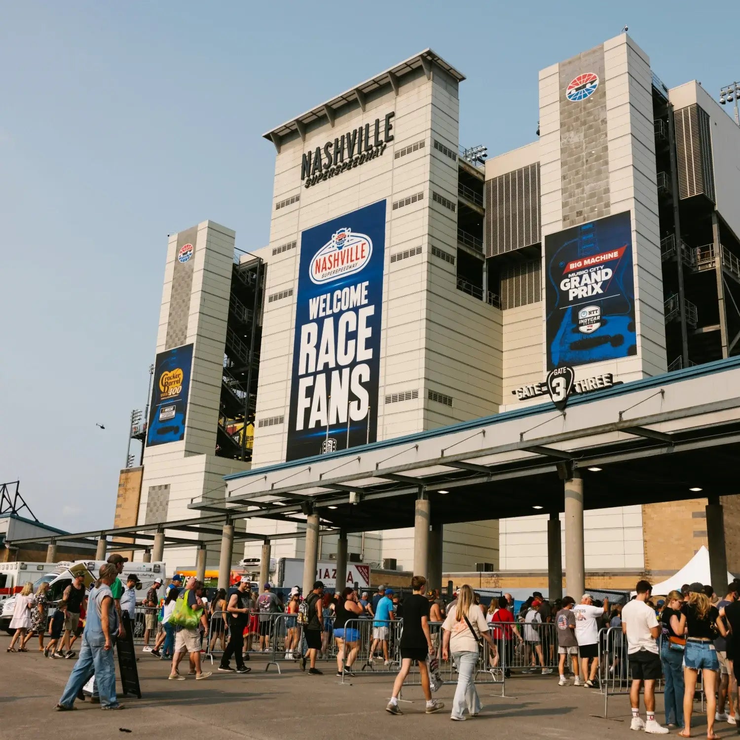 Crowds of fans arriving at the Nashville Superspeedway entrance for a NASCAR race day.