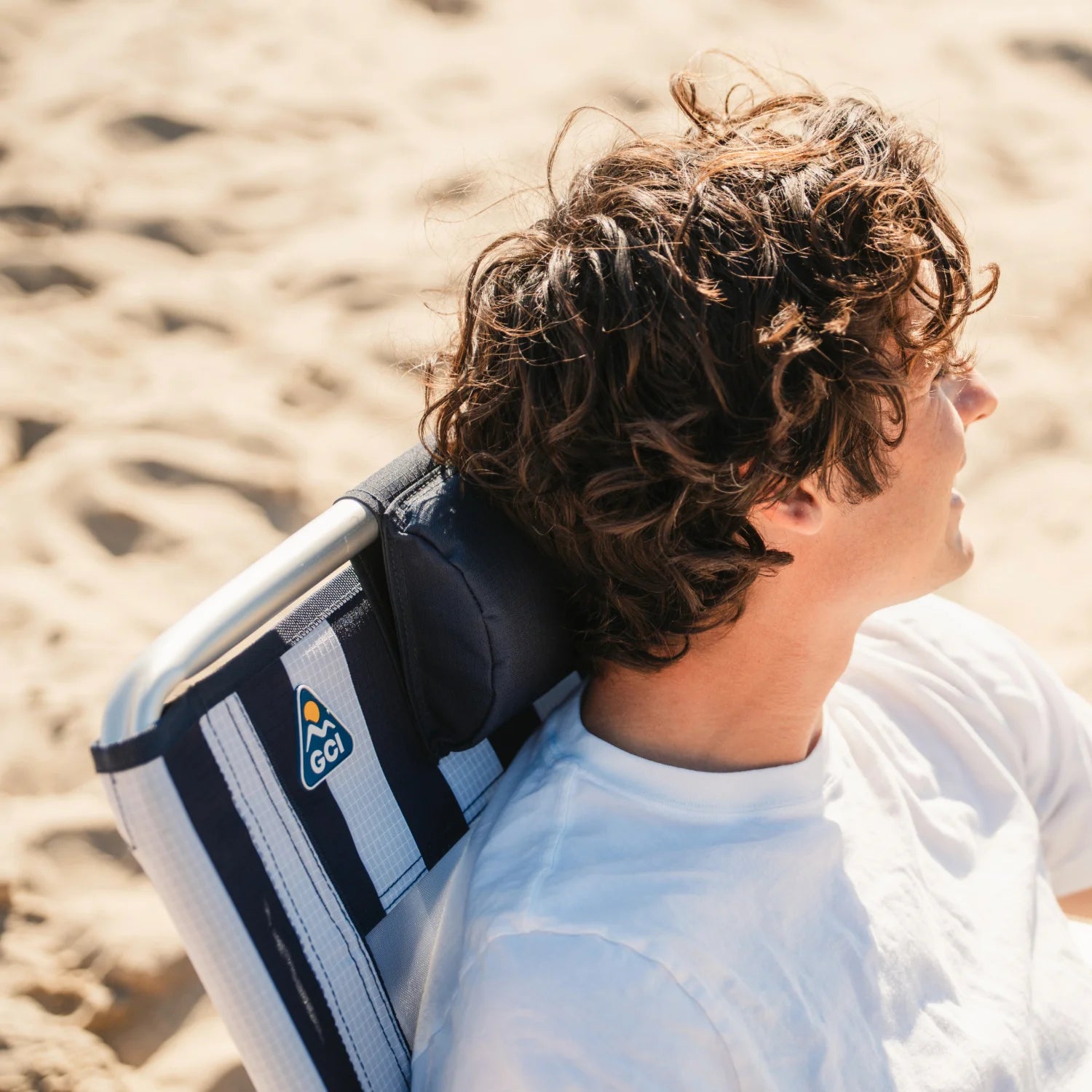 Padded headrest on TidalDrift indigo stripe backpack beach chair for comfortable lounging.