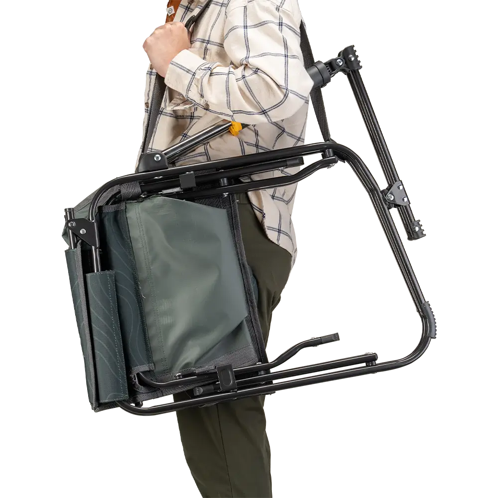 A person carrying the Hunter Topo Stowaway Rocker with a carry strap. 