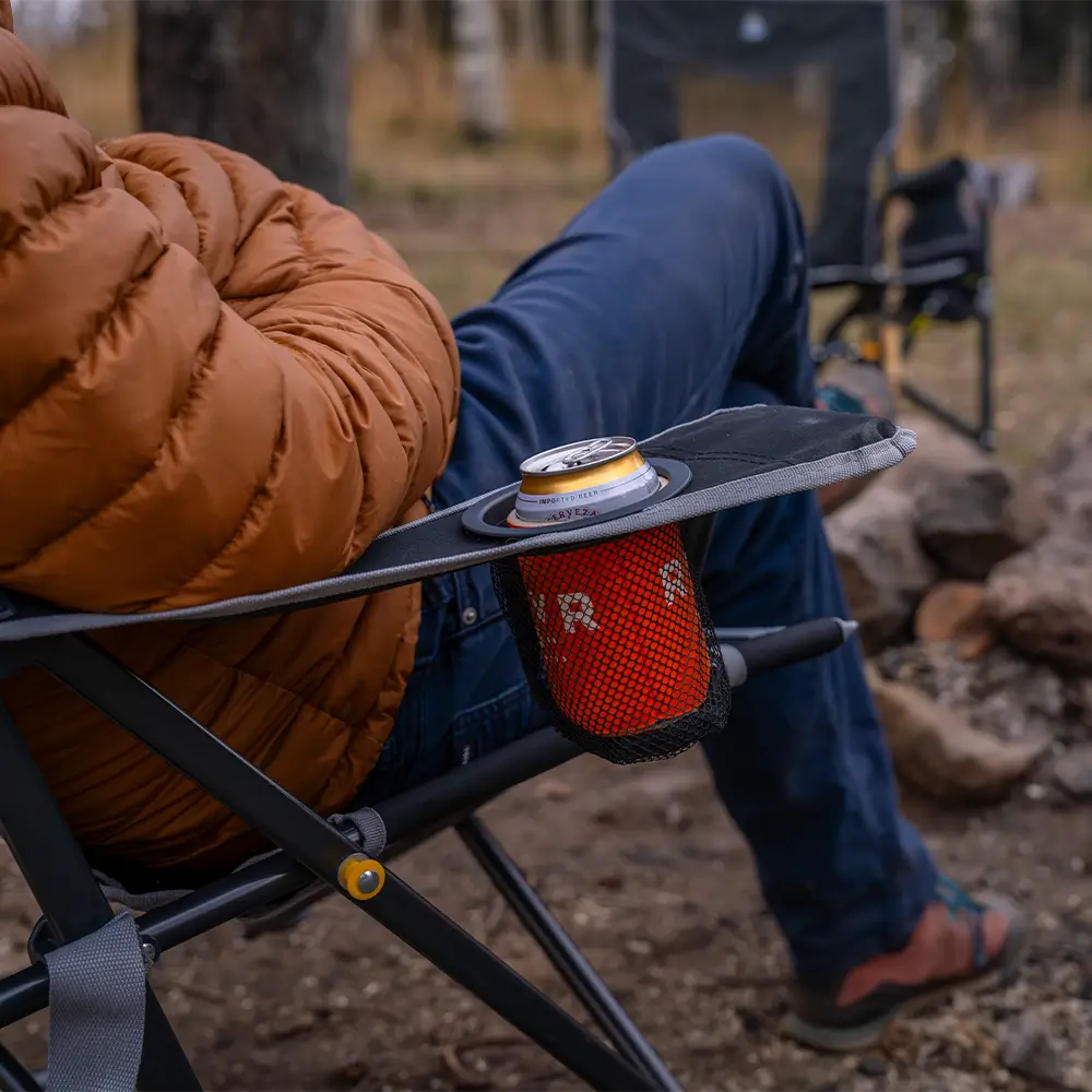A drink inside the cup holder of a black comfort pro rocker chair. 