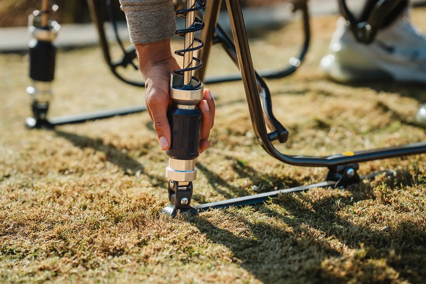A person adjusting the shock tension on their adjustable rocker chair. 