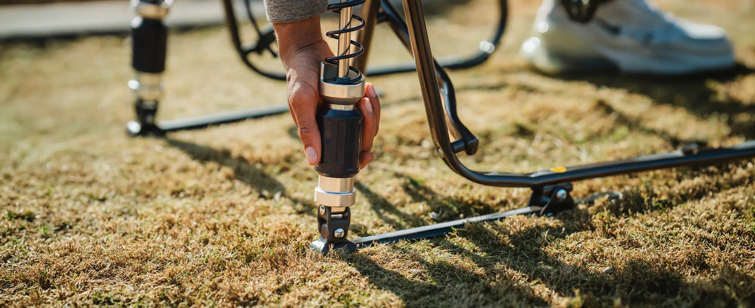 A person adjusting the shock tension on their adjustable rocker chair. 