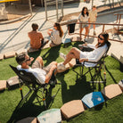Group relaxing in Black Breeze Rockers beside a baseball field during an outdoor event.