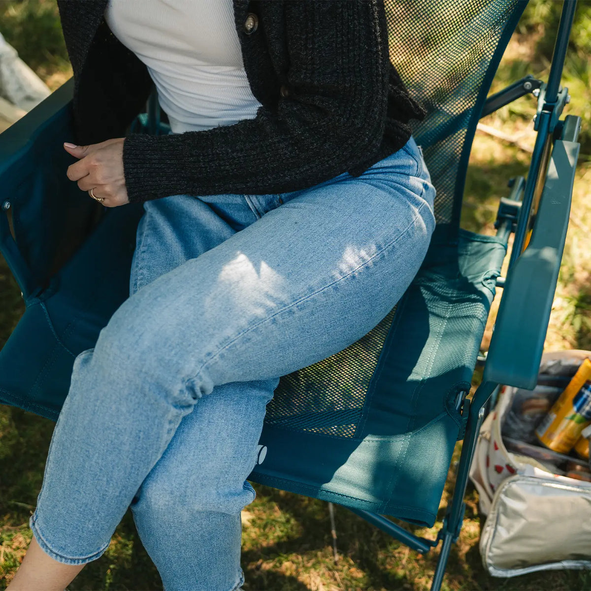 An aerial view of a woman sitting on a teal BreezeRocker showing the mesh backrest and seat. 