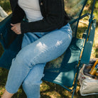 An aerial view of a woman sitting on a teal BreezeRocker showing the mesh backrest and seat. 