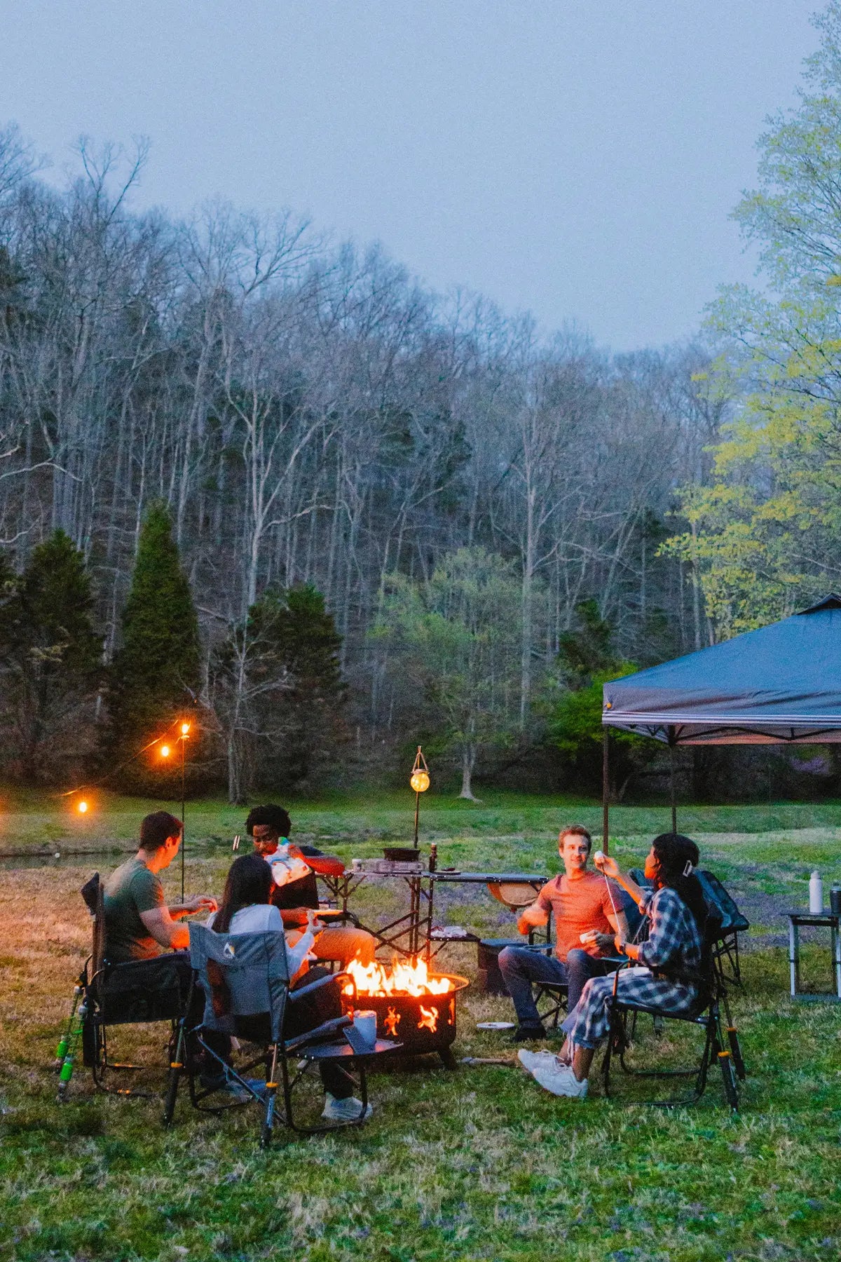 A group of people around a campfire sitting in their GCI Outdoor gear. 