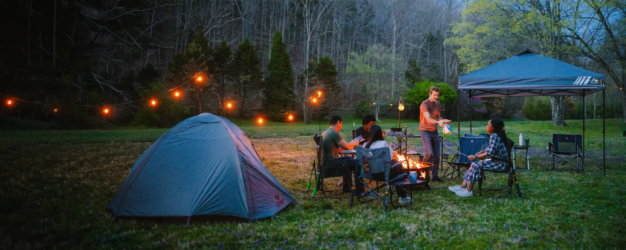 A group of people around a campfire sitting in their GCI Outdoor gear. 