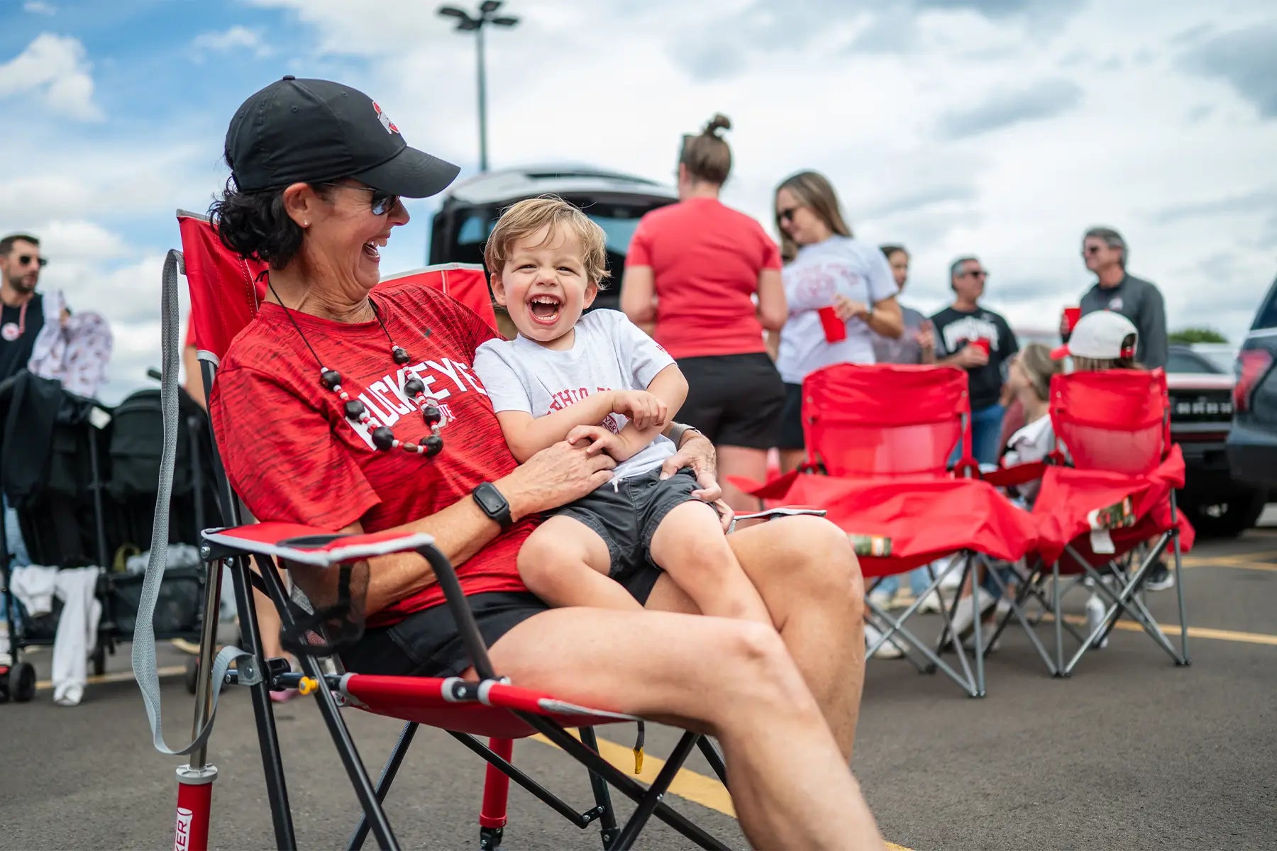 A woman holding a child that is laughing while sitting in their buckeyes comfort pro rocker chair. 