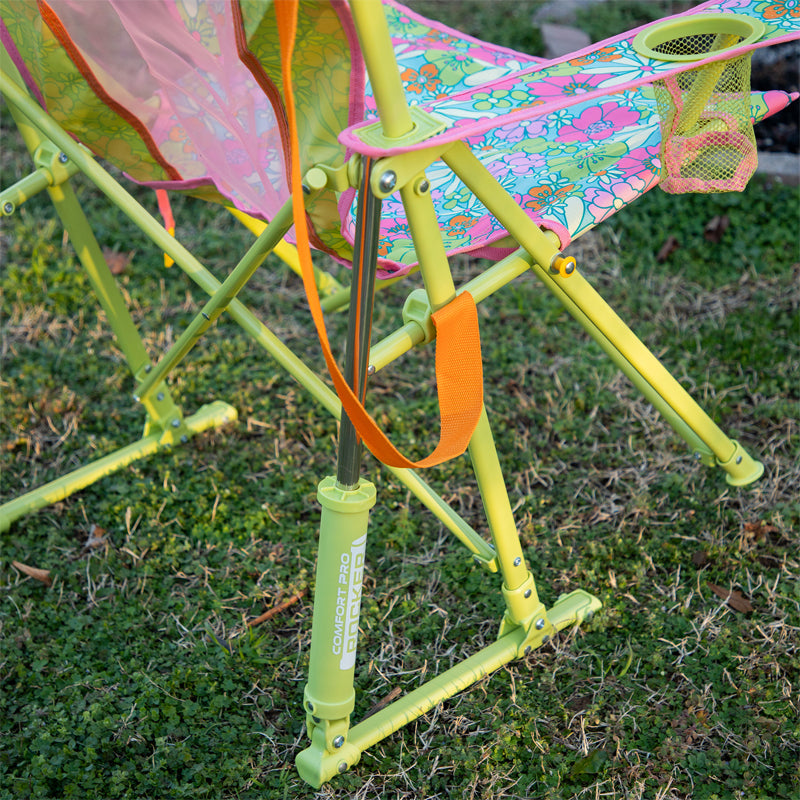Close-up of floral seat and Comfort Pro Rocker leg on green grass.