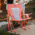 GCI Outdoor Comfort Pro Rocker in Coral Garden, front right angle view, at a backyard gathering.