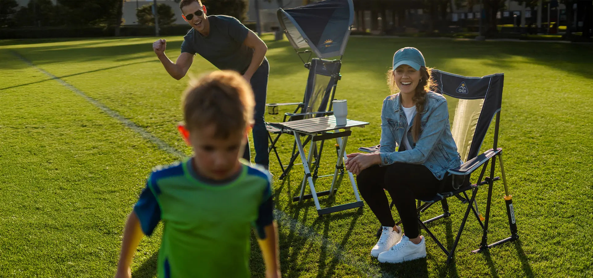 A woman cheering on a child while sitting in their comfort pro rocker chairs. 