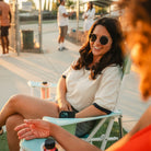 Woman lounging in a pastel green Comfort Pro Rocker at an outdoor gathering.