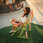 A top view of a woman sitting in the sweet tea Comfort Pro Rocker as she watches a baseball game. 
