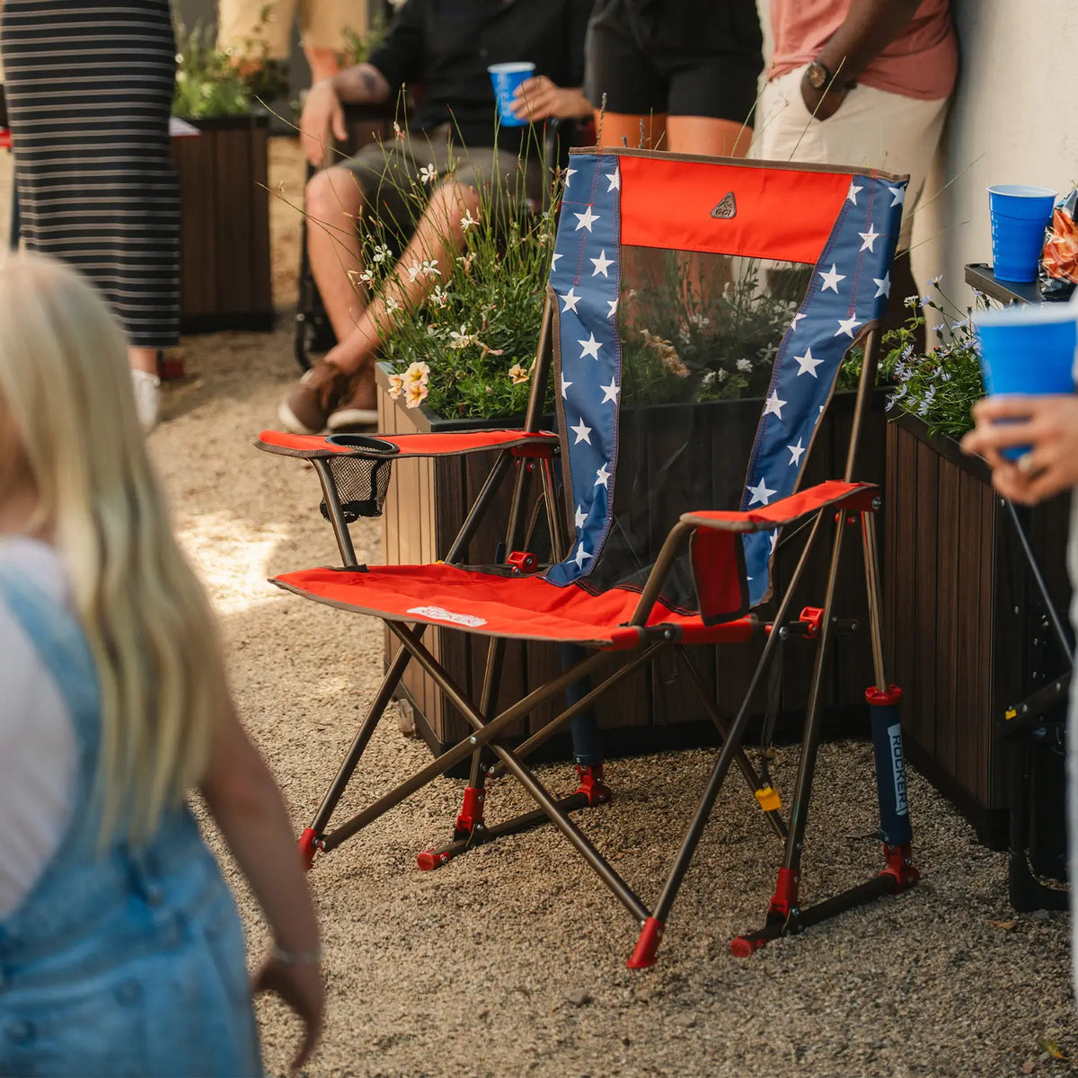 The USA Comfort Pro Rocker positioned next to a garden bed. 