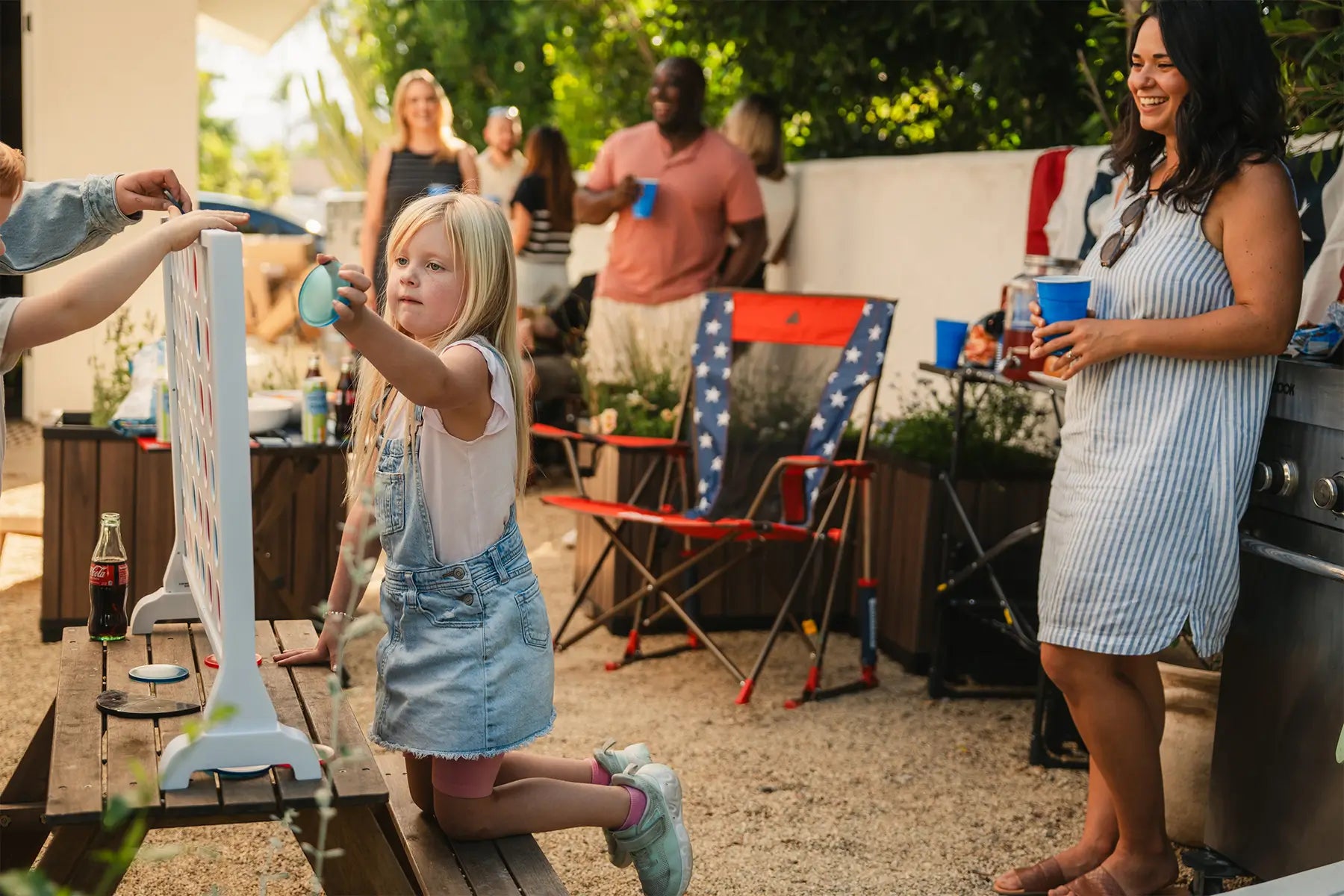 A child playing connect four while a USA Comfort Pro Rocker is behind her. 