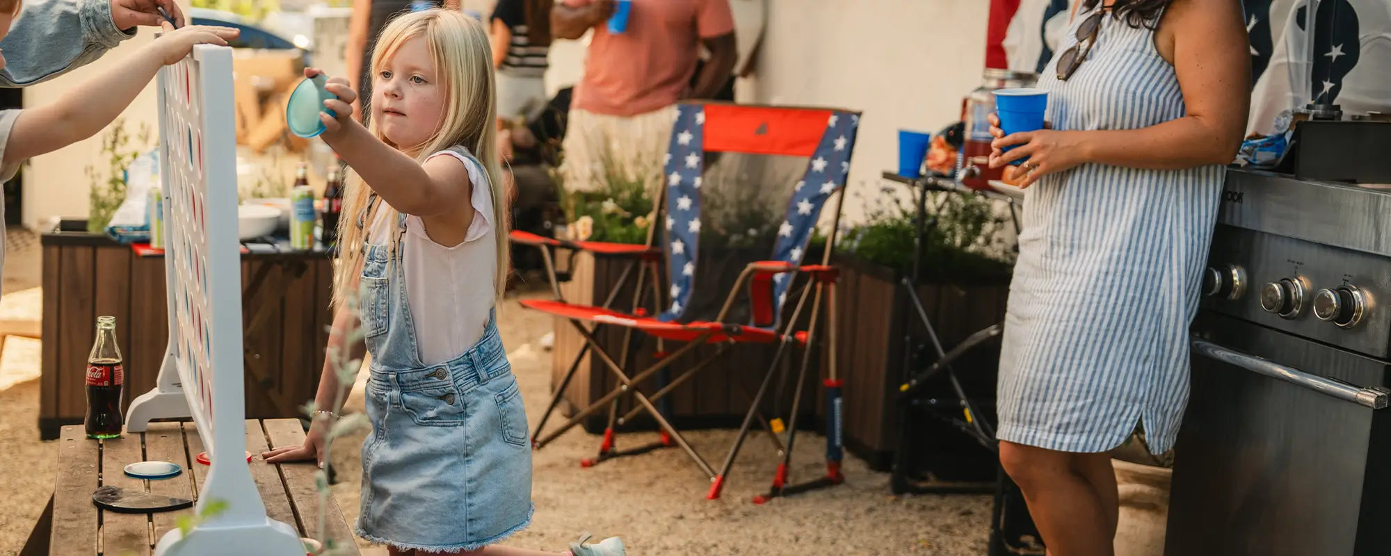 A child playing connect four while a USA Comfort Pro Rocker is behind her. 