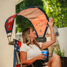 A woman adjusting the attached USA Sunshade Accessory to her Comfort Pro Rocker. 