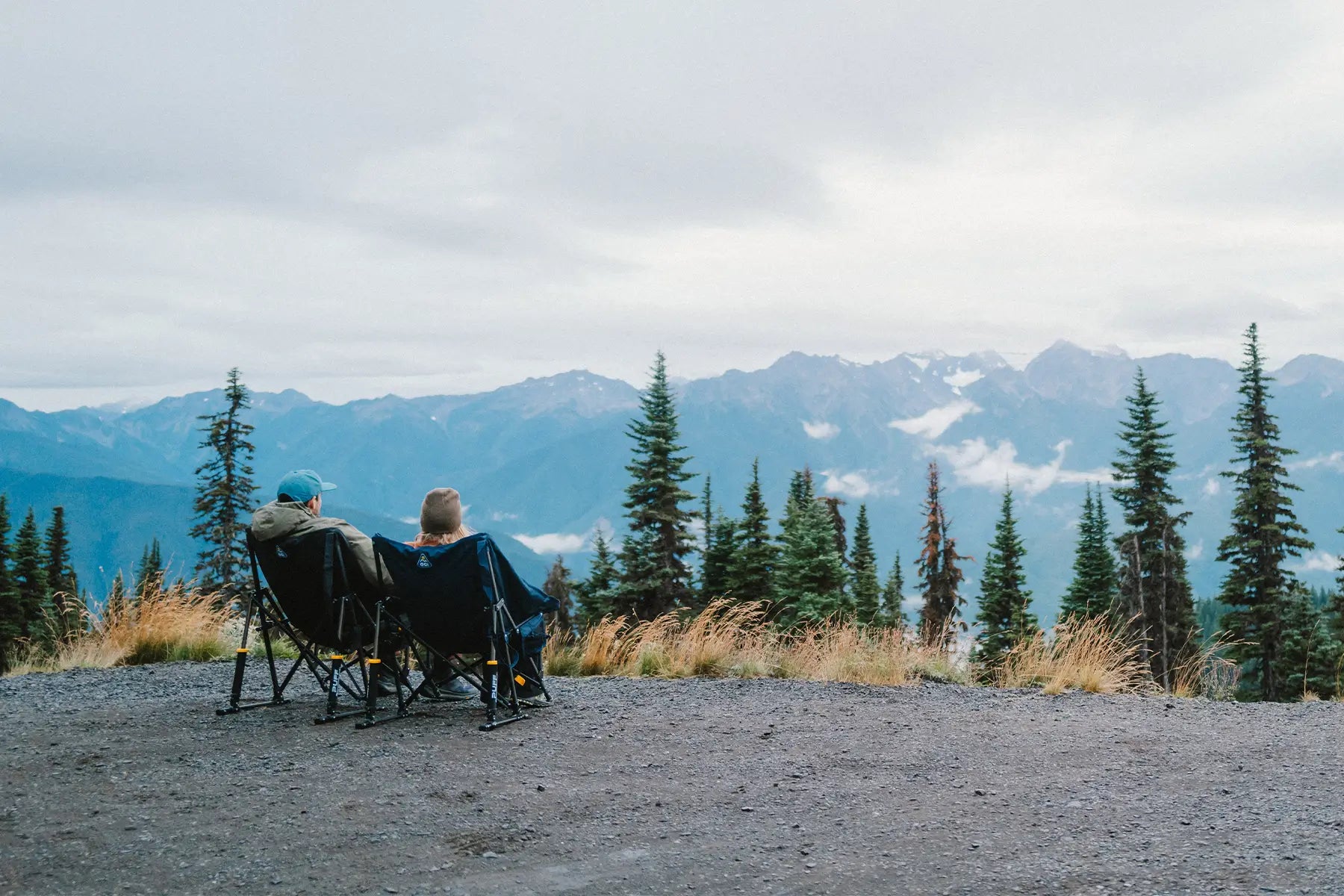 A couple sitting in two puff rockers while enjoying the view of an overlook. 