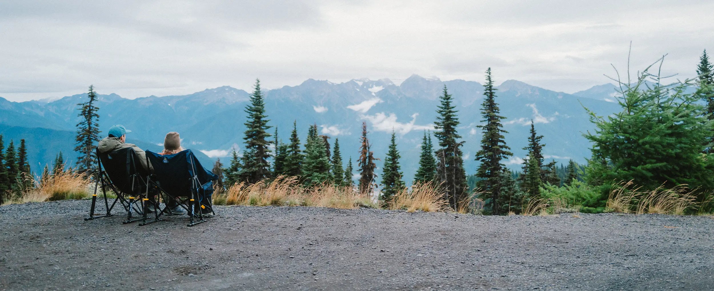 A couple sitting in two puff rockers while enjoying the view of an overlook. 