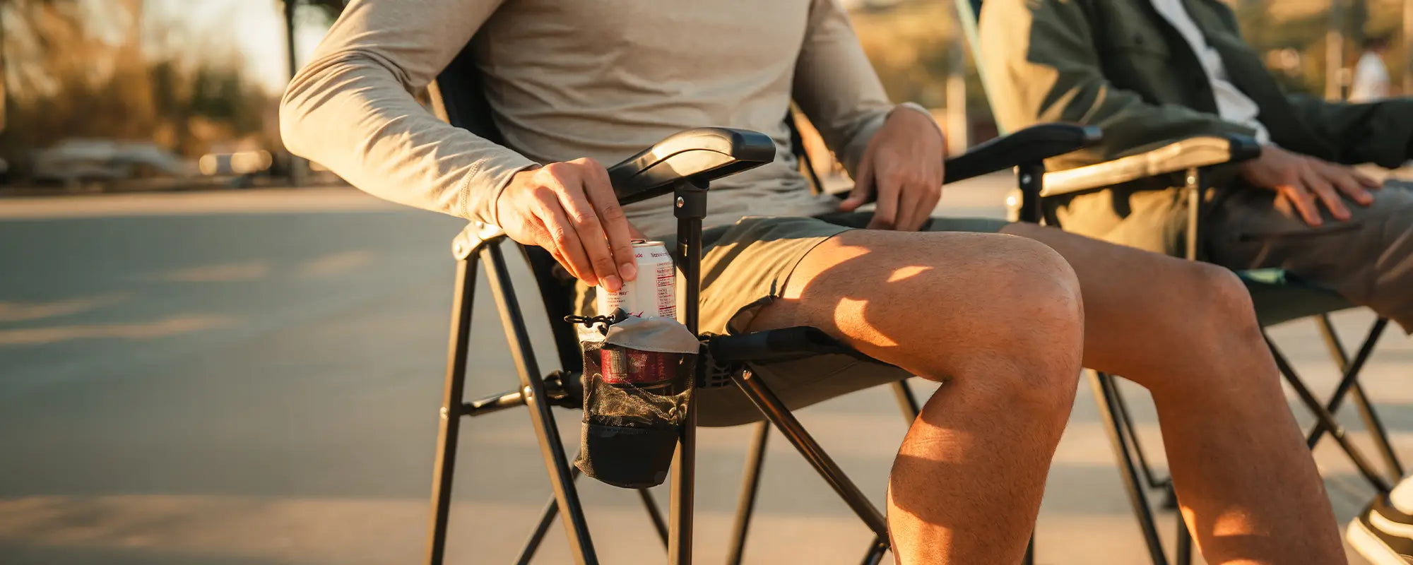 A person reaching for their drink in the integrated cup holder of the Eazy Chair. 